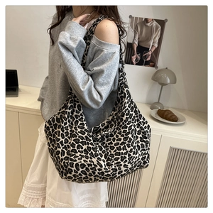 Détail du grand sac cabas à motif léopard porté à l'épaule pour un trajet quotidien élégant