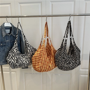 Grandi borse hobo con stampe zebra, plaid e leopardo appese a un supporto in metallo