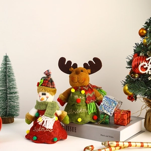 Close-up of Christmas snowman and reindeer plush gift bags with festive knitted decor