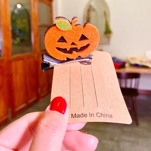3D pumpkin hair clip for Halloween with orange felt and glittery green leaf detail