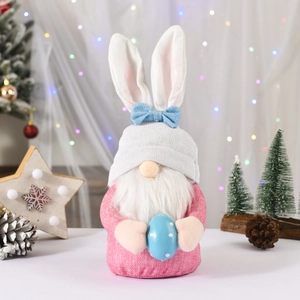 Gnomo pasquale con orecchie rosa e barba bianca che tiene un uovo a pois blu