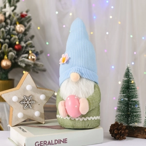 Dettaglio di uno gnomo pasquale con un uovo a pois rosa e luci festive
