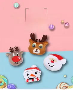 Macro detail of plush Christmas brooches featuring Santa, snowman, and reindeer designs