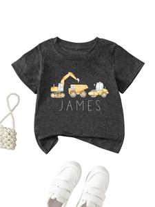 Close-up of a personalized kids' grey t-shirt featuring cartoon construction truck prints