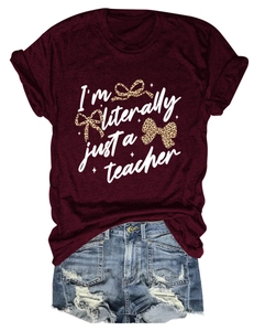 Close-up of a burgundy teacher T-shirt featuring a leopard print bow and white script text