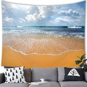 Detailed texture of a tropical sunset beach wall tapestry above a gray sofa in a room