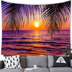 Tropical sunset beach tapestry featuring palm tree silhouettes above a modern gray sofa