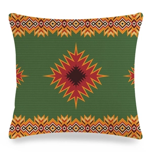 Détail du motif géométrique tribal bohème sur une housse de coussin vert foncé