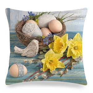 Easter linen pillowcase with floral eggs, wooden birds, and yellow daffodils on blue wood