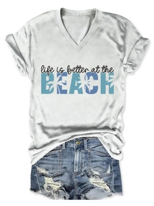 Macro detail of the beach slogan print on a white V-neck cotton T-shirt for women
