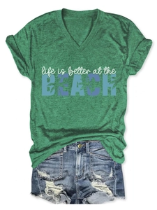 Detail of green V-neck T-shirt with Beach print and distressed denim shorts set
