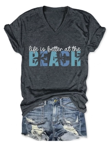 Flat lay of gray V-neck tee with Beach slogan and ripped denim shorts outfit