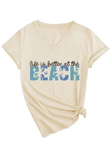 Detail of V-neck beige t-shirt featuring BEACH lettering and a stylish front-knot hem