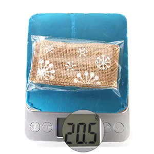 Detail showing natural jute ribbon with white snowflake pattern weighing 20.5g on scale