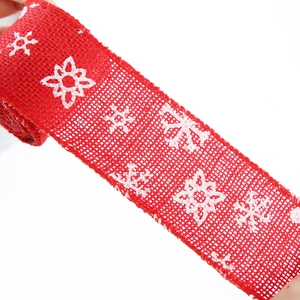 Detail of red burlap Christmas ribbon with white snowflakes for gift wrapping and DIY