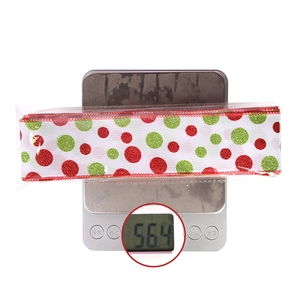 Detailed view of Christmas ribbon with red and green glitter dots on an electronic scale