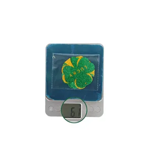Close-up of Lucky shamrock swirl charm made of green glitter material weighing 6.1g