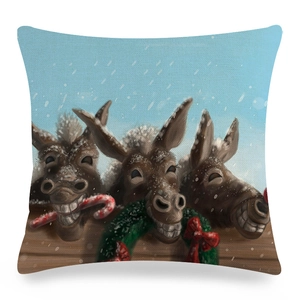 Detalle de funda de cojín de lino con burros festivos en una escena de nieve blanca