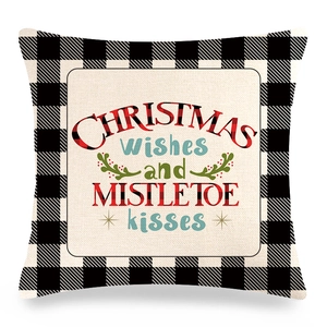 Détail de la housse de coussin de Noël à carreaux avec texte festif mistletoe kisses
