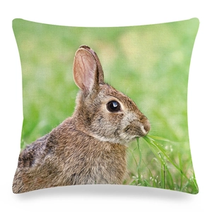 Detailed view of linen cushion cover with realistic brown rabbit eating grass design