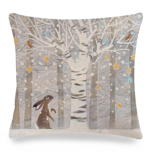 Detail of linen pillow cover with a cartoon rabbit, white tree, and bird illustration