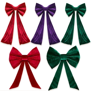 Flat lay of velvet bow decorations in burgundy, purple, and green for party DIY styling