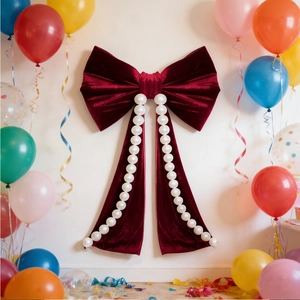 Close-up of a giant red velvet bow with white pearl accents for party background decor