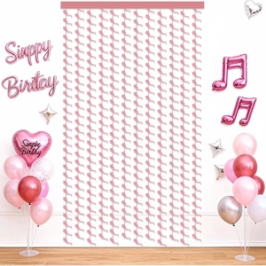 Pink foil fringe curtain backdrop with heart balloons for birthday party decor