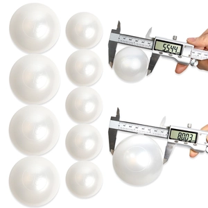 Detail view of large white imitation pearls with caliper measuring 55mm and 80mm sizes