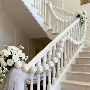 Close-up of elegant wedding staircase décor featuring large white pearls and airy white tulle