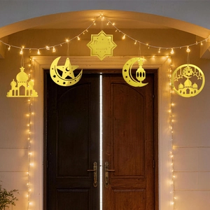 Decorazioni sospese dorate del Ramadan con luna e stelle su sfondo di porta in legno