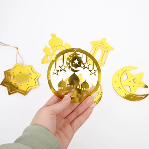 Dettaglio di ciondolo dorato traforato per Ramadan con design moschea e specchio