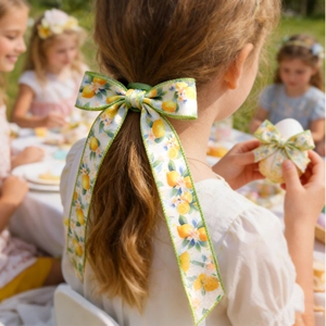 Detailansicht einer Haarschleife mit Zitronenmuster, getragen bei einem Picknick im Freien