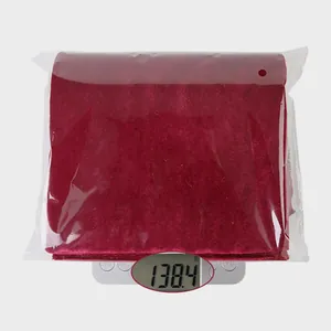 Detail view of large red velvet bow decor on a digital scale weighing 138.4 grams
