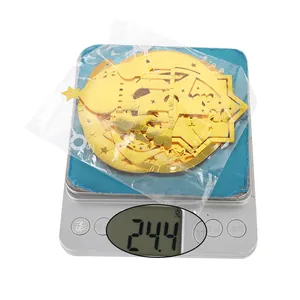 Detailed view of gold Eid hanging ornaments weighing 24.4g on a precision digital scale