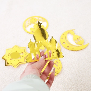 Detail of gold mirror Ramadan decorations featuring mosque and moon cutout shapes
