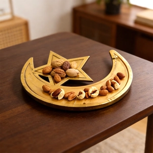 Golden moon and star metal tray set on a wooden table for nuts and festive decorations