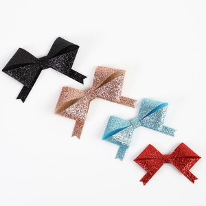 Nahaufnahme bunter Glitzer-Schleifen in Schwarz, Roségold, Blau und Rot für DIY-Bastelarbeiten
