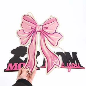 Dettaglio del pendente in legno per la Festa della Mamma con fiocco rosa e MOM