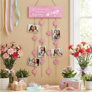Close-up of pink wooden hanging photo display with strings, clips and floral patterns