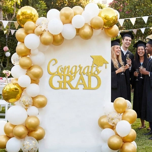 Detail of Congrats GRAD gold glitter topper and balloon arch decoration for party