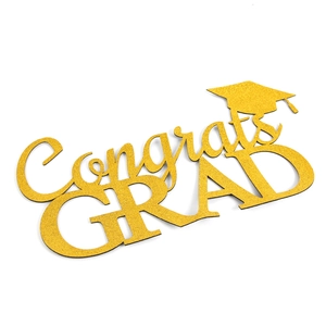 Close-up of gold glitter Congrats GRAD sign with a graduation cap for party decor