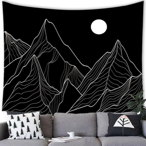 Abstract landscape tapestry featuring black and white mountains and moon over a modern sofa
