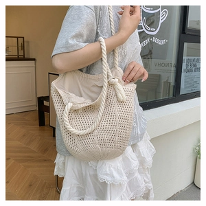 Close-up of cream woven cotton tote bag featuring chunky knotted handles and spacious interior
