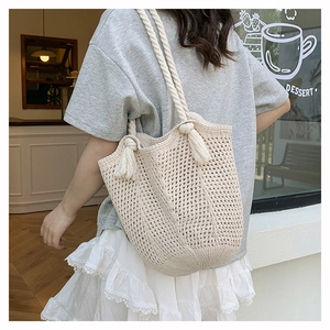 Detail of bohemian woven shoulder bag with thick rope handles and fringe tassels