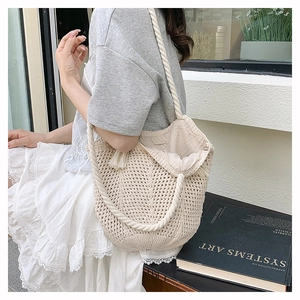 Detail of hollow-out crochet tote bag featuring thick cotton rope straps and inner lining