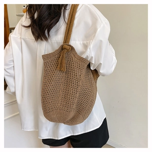 Detailed texture of brown knit weave tote bag with fringe tassels and rope strap