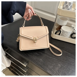 Detail of apricot crossbody bag with golden twist lock and matte leather finish