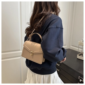 Vue détaillée du sac bandoulière en cuir beige avec élégant fermoir en anneau doré