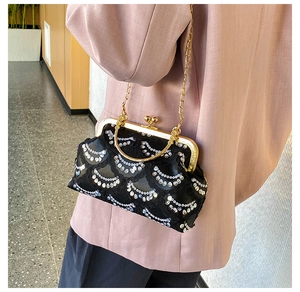 Detail of black sequined evening clutch bag with vintage gold clasp and metal chain